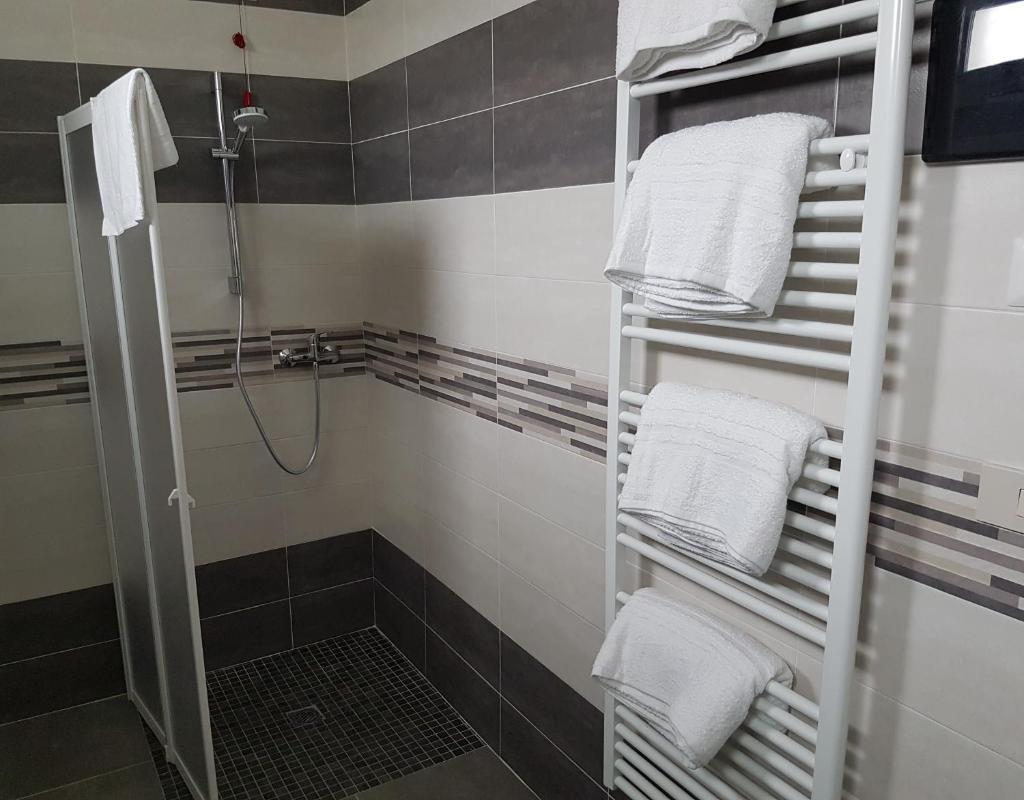 un porte-serviettes dans une salle de bain avec des serviettes blanches dans l'établissement Hotel Damma's, Dipendenza Zamagna, à Cesenatico