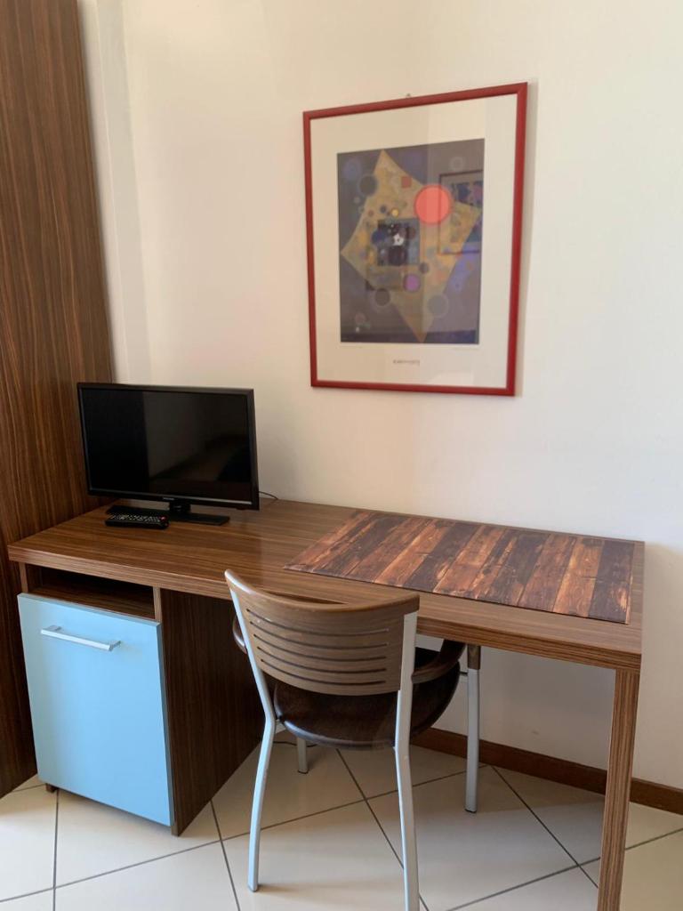 Cette chambre comprend un bureau avec un ordinateur et une chaise. dans l'établissement Hotel & Residence La Sibilla Cusiana, à Pettenasco
