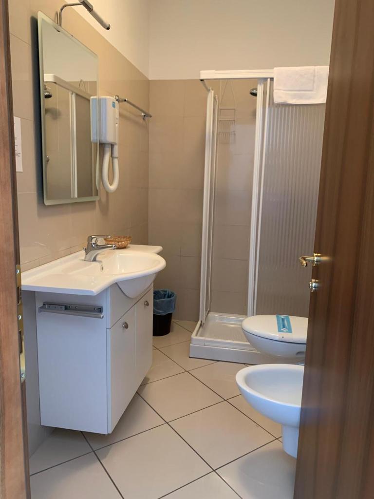 une salle de bain avec un lavabo, des toilettes et une douche dans l'établissement Hotel & Residence La Sibilla Cusiana, à Pettenasco 74 autres photos