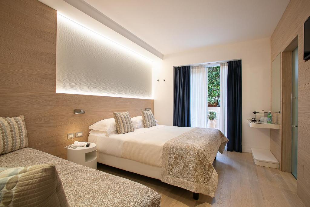 une chambre d'hôtel avec un lit et une fenêtre dans l'établissement Hotel Daniele, à Lignano Sabbiadoro