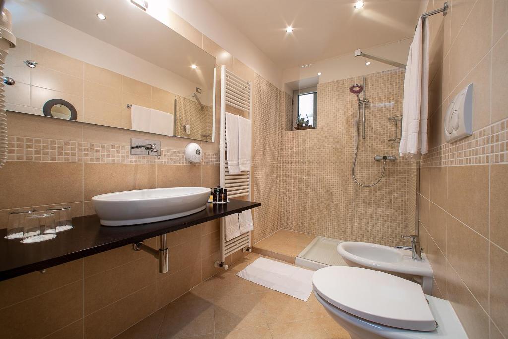 une salle de bain avec un lavabo, des toilettes et une douche dans l'établissement Hotel Daniele, à Lignano Sabbiadoro 37 autres photos