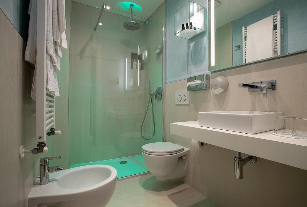 une salle de bain avec toilettes, lavabo et douche dans l'établissement Hotel Daniele, à Lignano Sabbiadoro