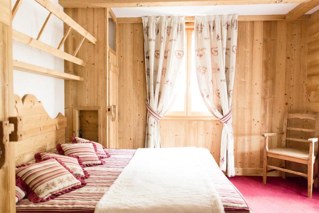 une chambre avec deux lits et une chaise et une fenêtre dans l'établissement Hôtel Le Sporting, à Morzine 37 autres photos
