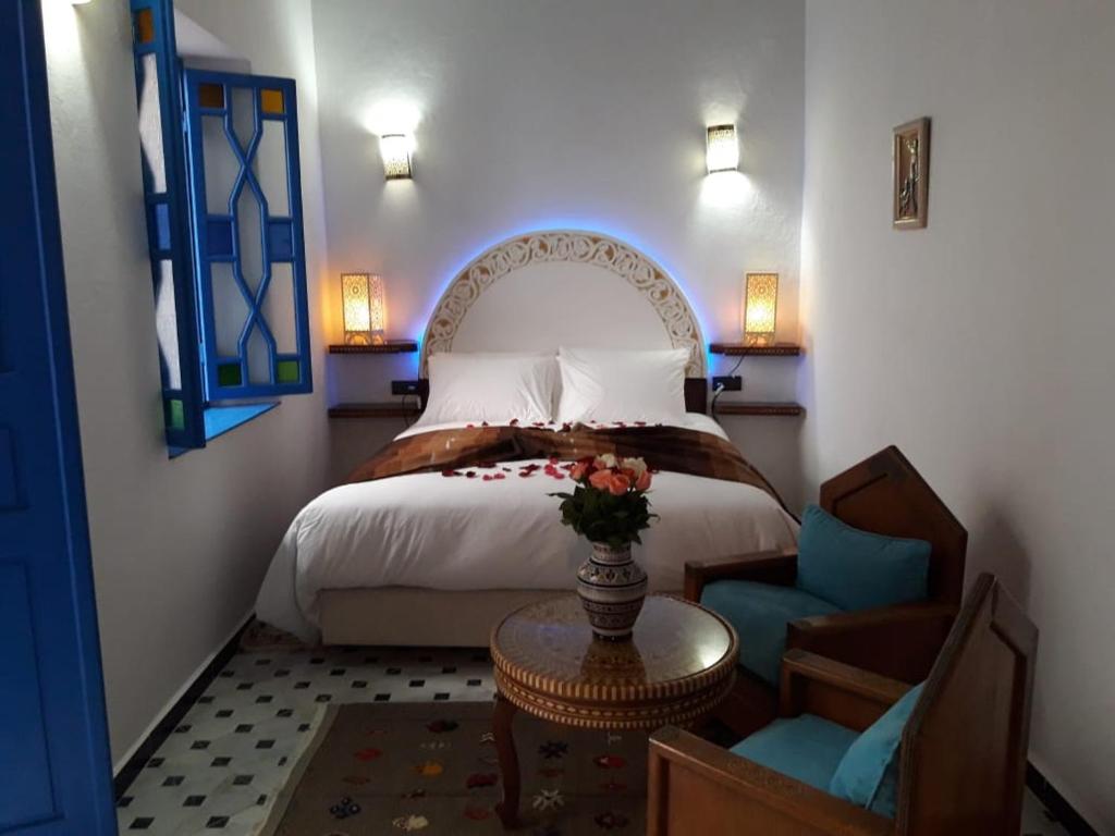 une chambre avec un lit, une table et une chaise dans l'établissement Riad Zawia, à Essaouira