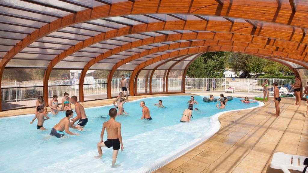 un groupe de personnes jouant dans une piscine dans l'établissement Glamping Villatent at Le Lac Bleu, à Châtillon-en-Diois