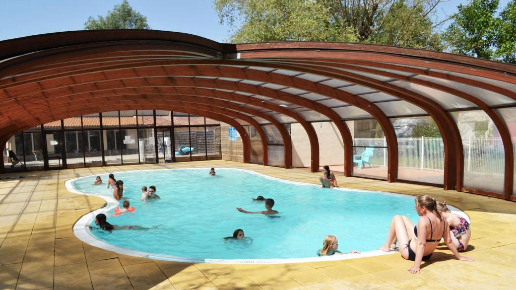 un groupe de personnes nageant dans une piscine dans l'établissement Glamping Villatent at Le Lac Bleu, à Châtillon-en-Diois