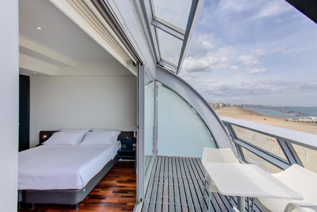 une chambre avec un lit et une vue sur la plage dans l'établissement Kursaal Hotel, à Cattolica