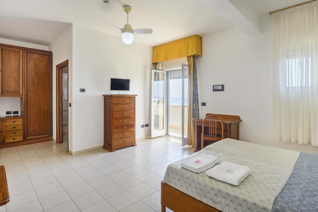 - une chambre avec un lit, une commode et une télévision dans l'établissement Hotel dei Bizantini & Villaggio Campo dei Messapi, à San Pietro in Bevagna