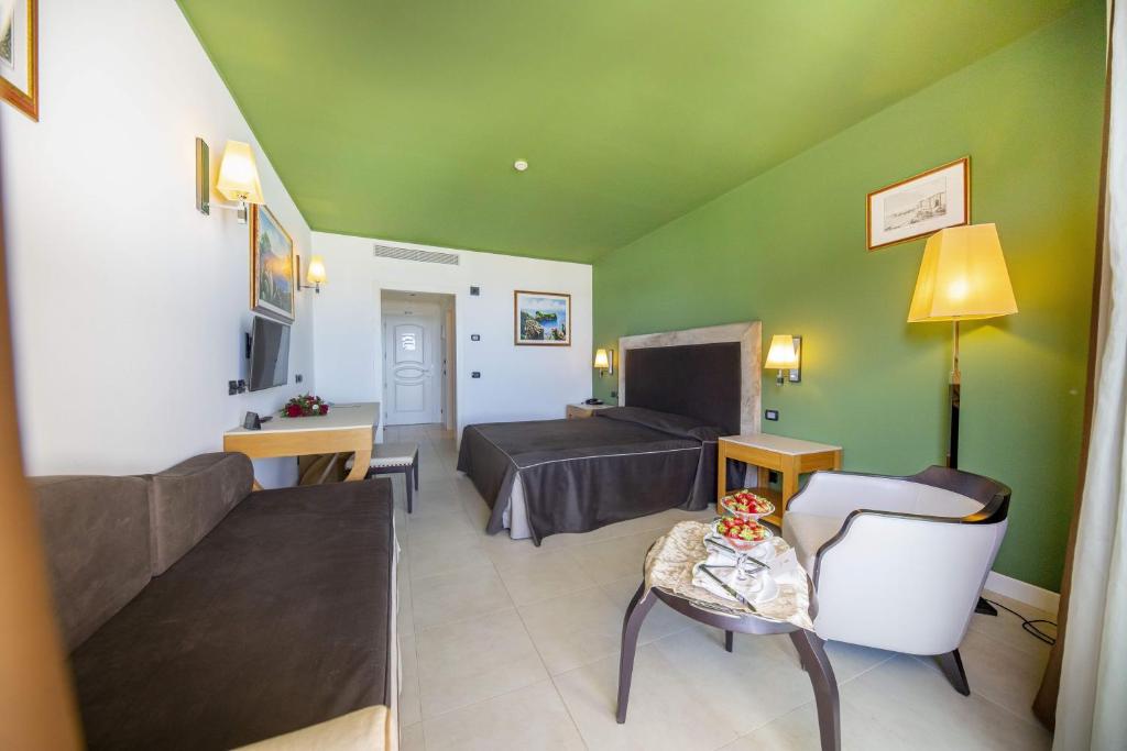 un salon avec un lit et un canapé dans l'établissement Cefalù Sea Palace, à Cefalù