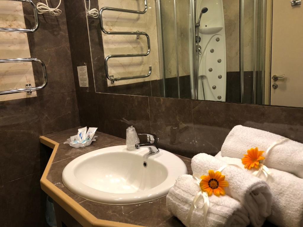 une salle de bain avec un lavabo avec des serviettes et un miroir dans l'établissement Domizia Palace Hotel, à Baia Domizia