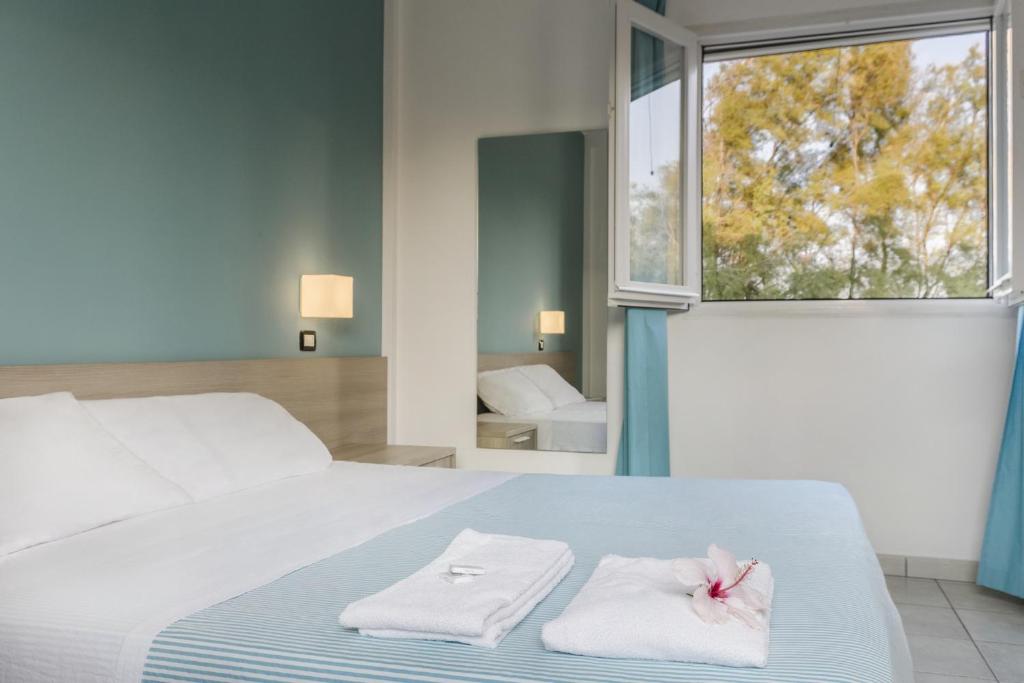 - une chambre avec un lit, des serviettes et une fenêtre dans l'établissement Hotel dei Bizantini & Villaggio Campo dei Messapi, à San Pietro in Bevagna 71 autres photos