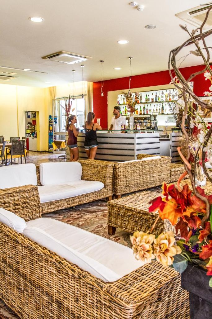 un restaurant avec des chaises en osier et un bar dans l'établissement Hotel Consul - Family Hotel, à Riccione