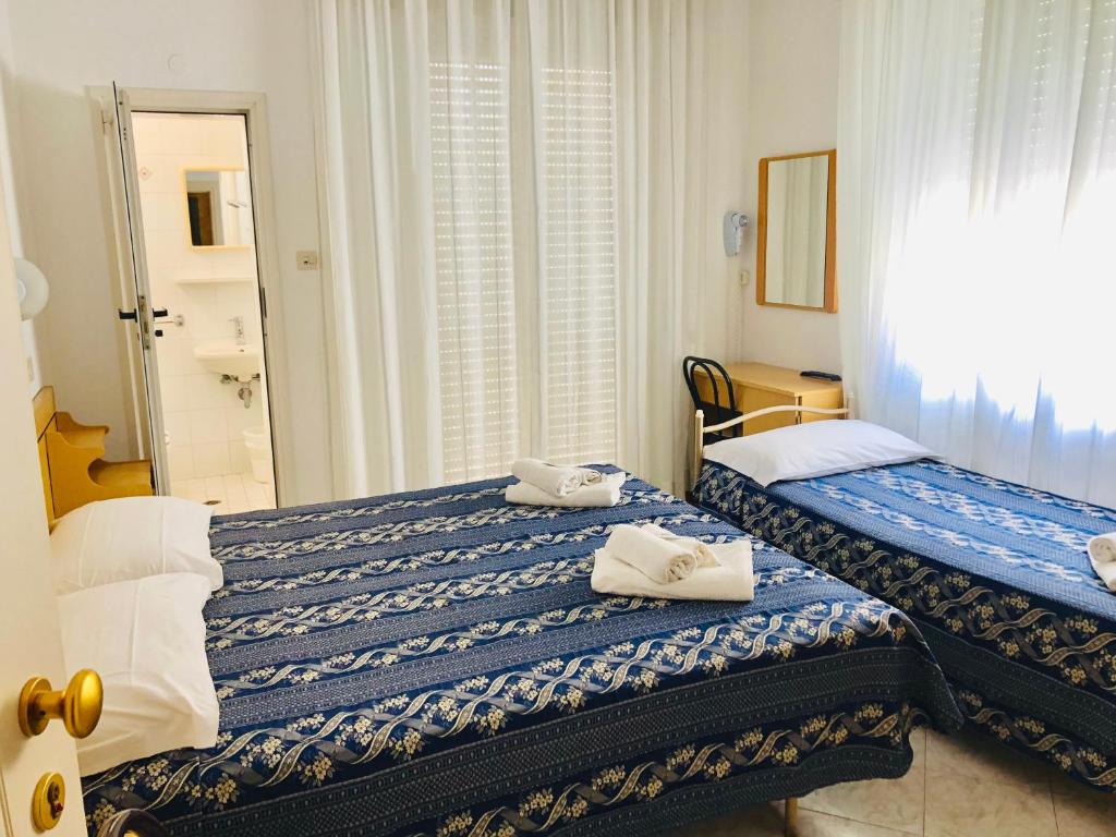 deux lits dans une chambre d'hôtel avec des serviettes dessus dans l'établissement Hotel Villa Lieta, à Rimini