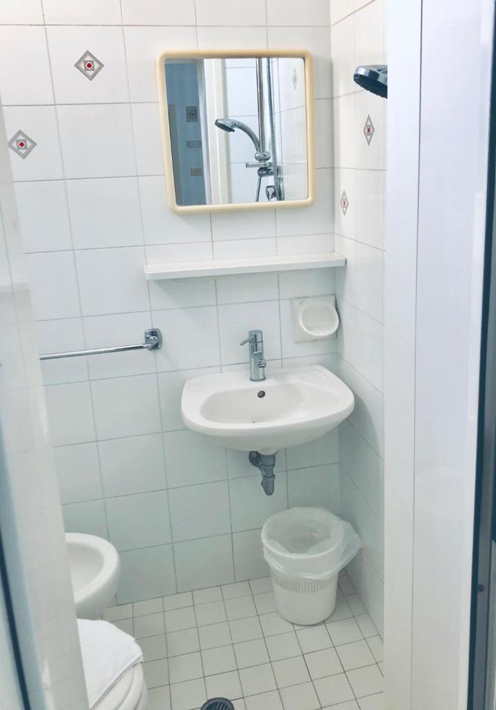 une salle de bain avec un lavabo, des toilettes et un miroir dans l'établissement Hotel Villa Lieta, à Rimini 35 autres photos