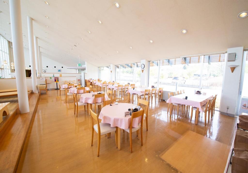 une salle à manger avec des tables et des chaises blanches dans l'établissement Kinta no sato, à Hamada