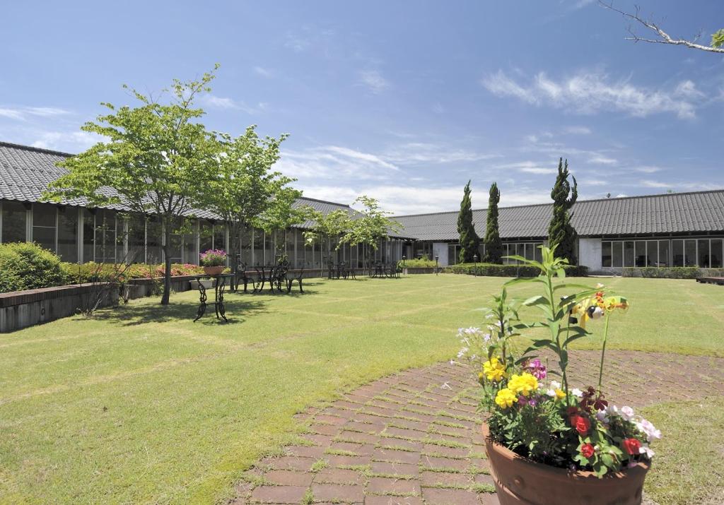- un jardin avec un chemin en briques et des fleurs dans une cour dans l'établissement Kinta no sato, à Hamada