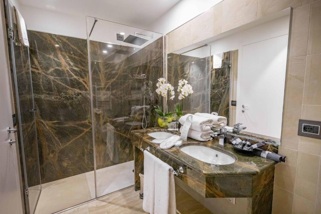 une salle de bain avec un lavabo et une douche dans l'établissement Victoria Palace Cefalù, à Cefalù