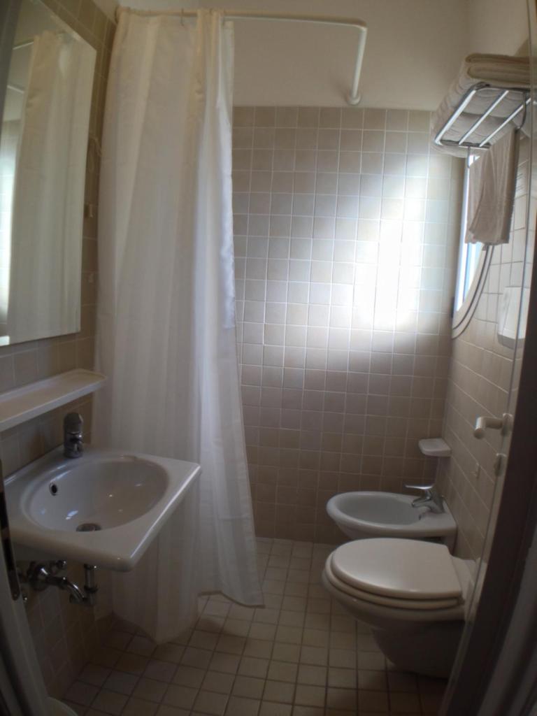 une salle de bain avec un lavabo, des toilettes et une douche dans l'établissement Hotel Houston, à Rimini 40 autres photos