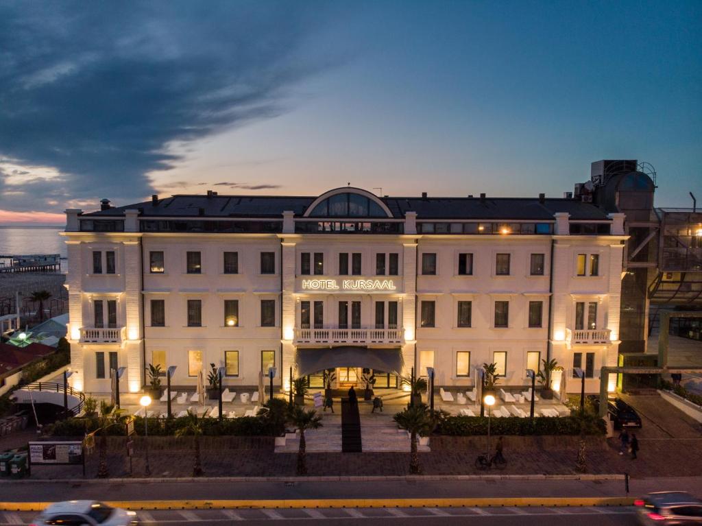 un grand bâtiment blanc éclairé dans l'établissement Kursaal Hotel, à Cattolica