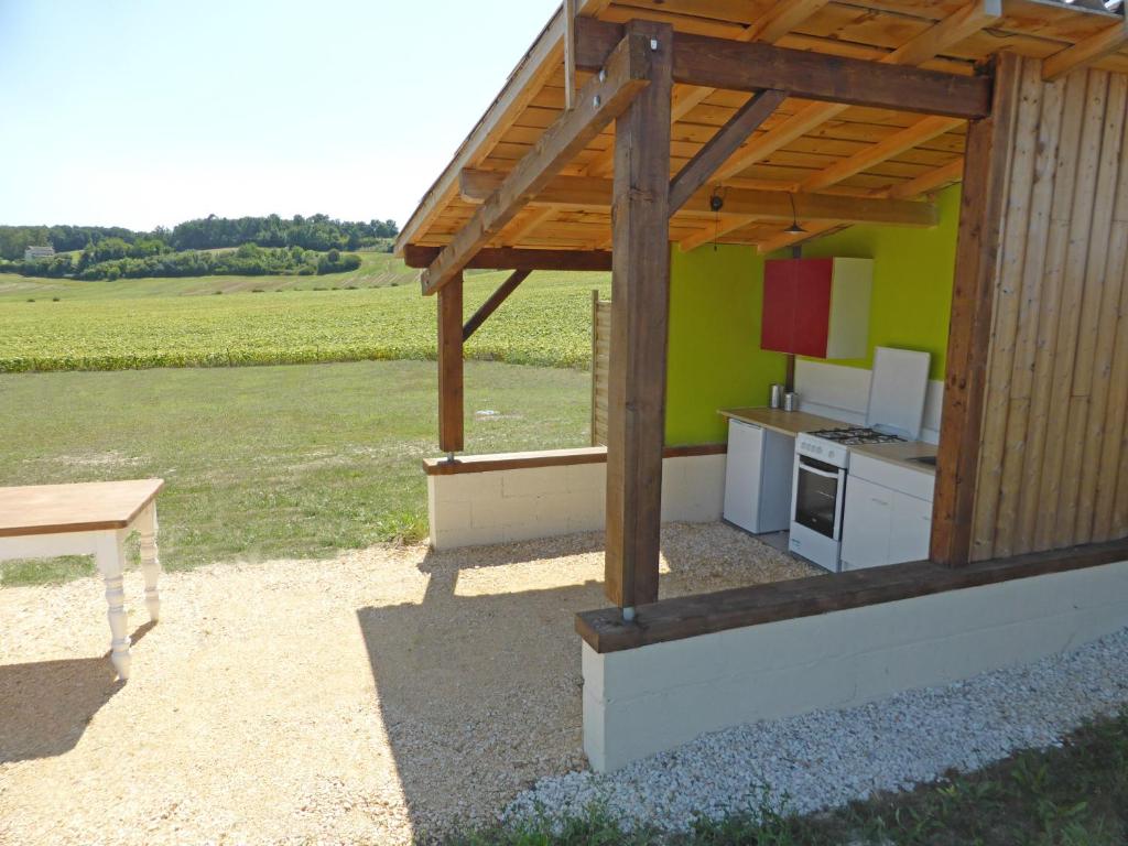une cuisine extérieure avec une pergola en bois dans l'établissement Les Yourtes d'Agnac, à Agnac
