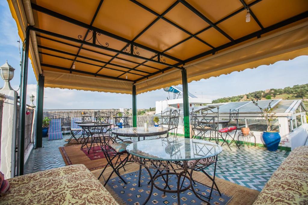 un groupe de tables et de chaises sur une terrasse dans l'établissement Riad L'Artiste, à Fès