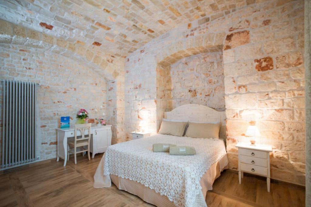 - une chambre avec un lit dans une pièce aux murs en pierre dans l'établissement HelloApulia - Masseria Petra Antica - Charming Family Retreat with Private Pool in Itria Valle, à Ceglie Messapica 55 autres photos