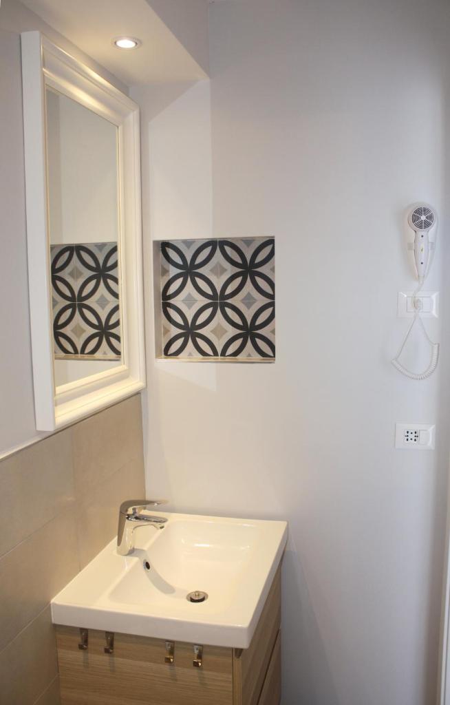 une salle de bain blanche avec un lavabo et une fenêtre dans l'établissement Hotel Helga, à Caorle 72 autres photos