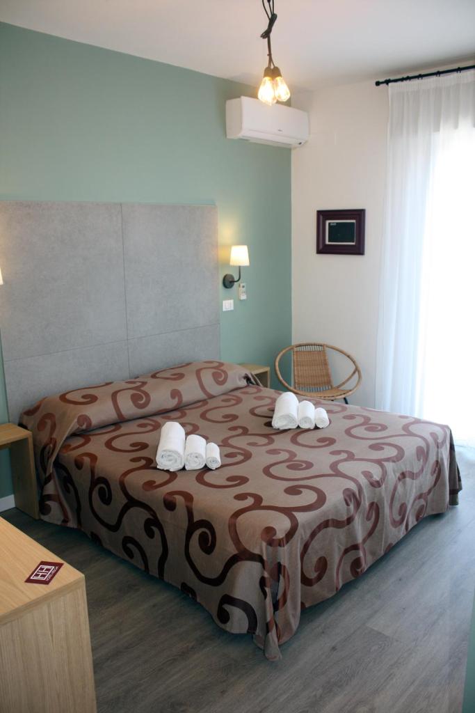 une chambre avec un lit avec deux serviettes dessus dans l'établissement Hotel Helga, à Caorle