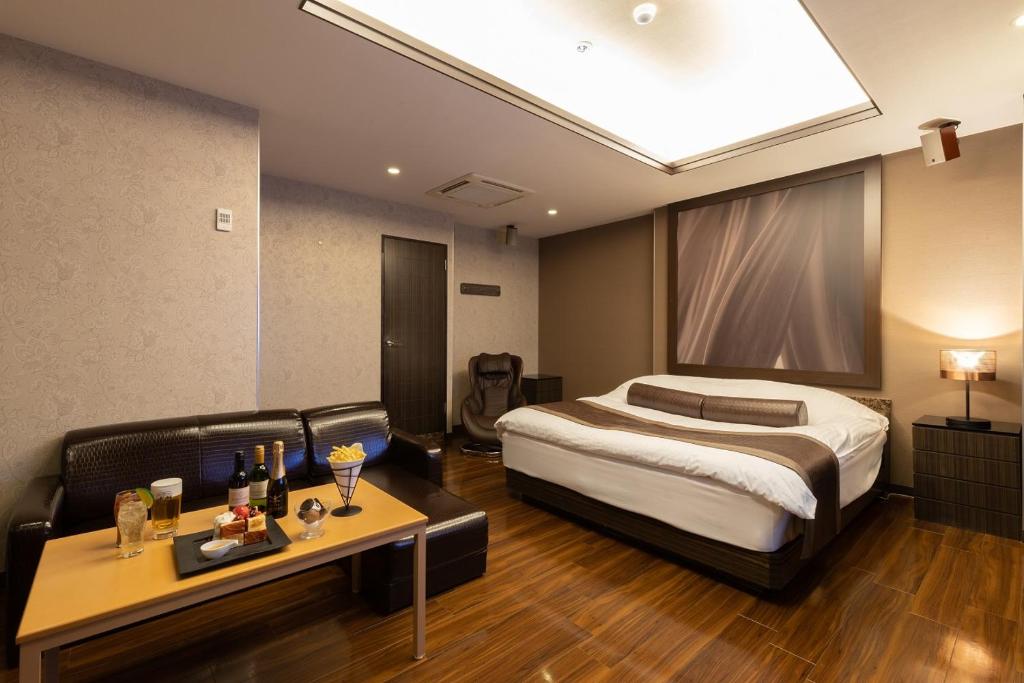une chambre d'hôtel avec un lit et un canapé dans l'établissement ホテル マイン 岐阜, à Ginan
