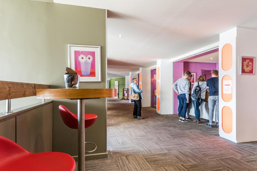 un groupe de personnes qui regardent l'art dans un couloir dans l'établissement Résidence Pierre & Vacances La Forêt, à Flaine