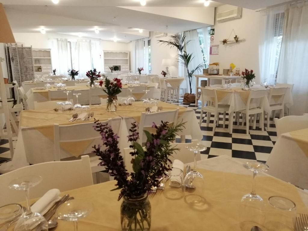 une salle de banquet avec des tables blanches et des chaises blanches dans l'établissement Hotel Petit, à Silvi Marina