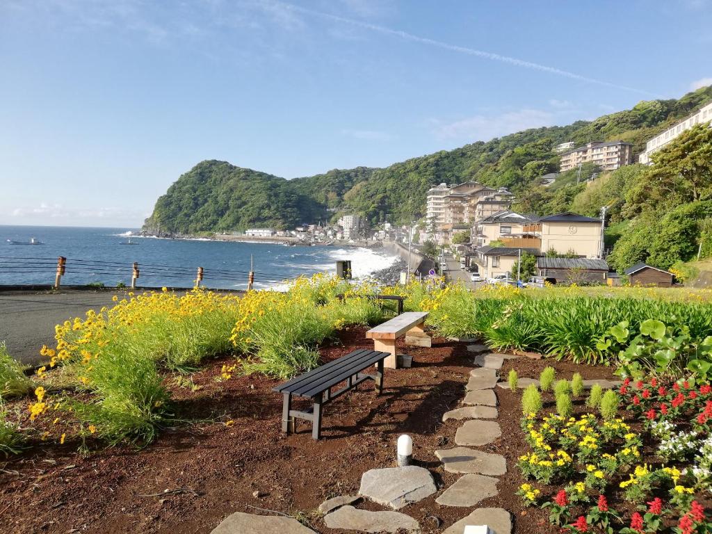 d'un banc dans un jardin avec vue sur l'océan. dans l'établissement Izu Hokkawa Seaside Guesthouse 伊豆北川の家, à Higashiizu