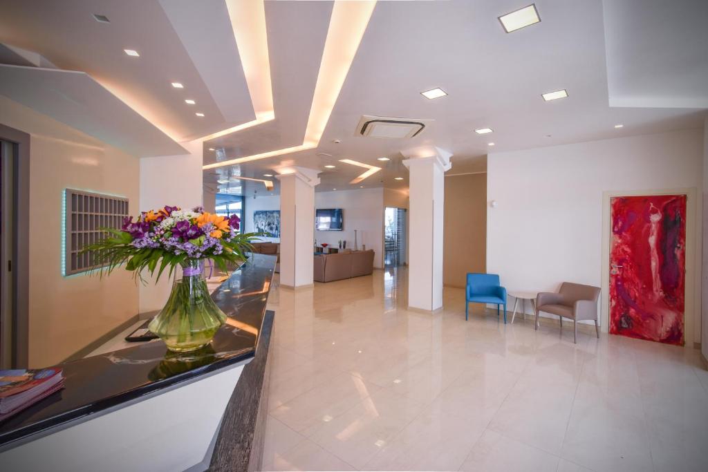 un hall d'entrée avec un vase de fleurs sur un comptoir dans l'établissement Hotel Delle Nazioni - Adults Only, à Caorle 146 autres photos