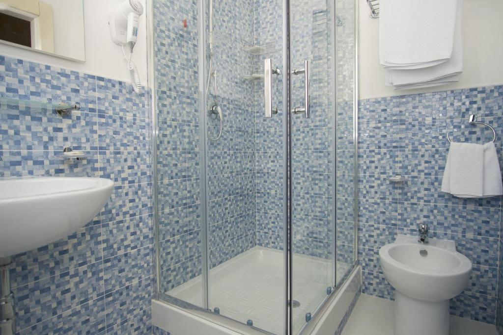 La salle de bains est pourvue d'une douche en verre, d'un lavabo et de toilettes. dans l'établissement Delfino, à Marina di Camerota