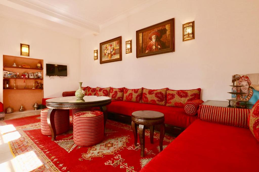 un salon avec un canapé rouge et une table dans l'établissement Dar Pamella, à Marrakech