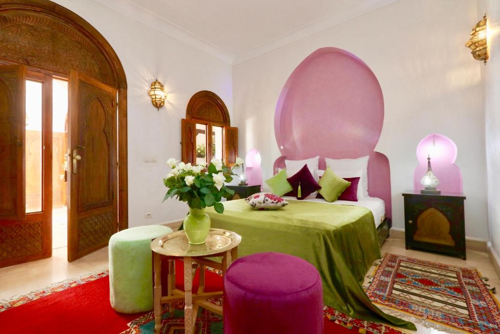 une chambre avec un lit avec un vase de fleurs dans l'établissement Dar Pamella, à Marrakech