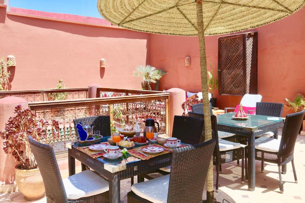 une table et des chaises avec un parasol sur une terrasse dans l'établissement Dar Pamella, à Marrakech