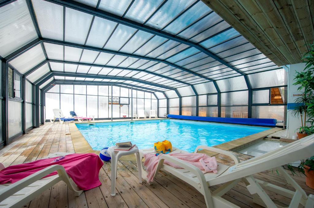 une grande piscine avec un plafond de verre dans l'établissement Résidence Goélia Le Village Gaulois, à Saint-François-Longchamp