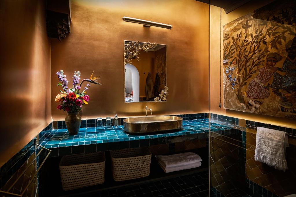 une salle de bain avec un lavabo et un vase de fleurs dans l'établissement Riad Kbour & Chou, à Marrakech