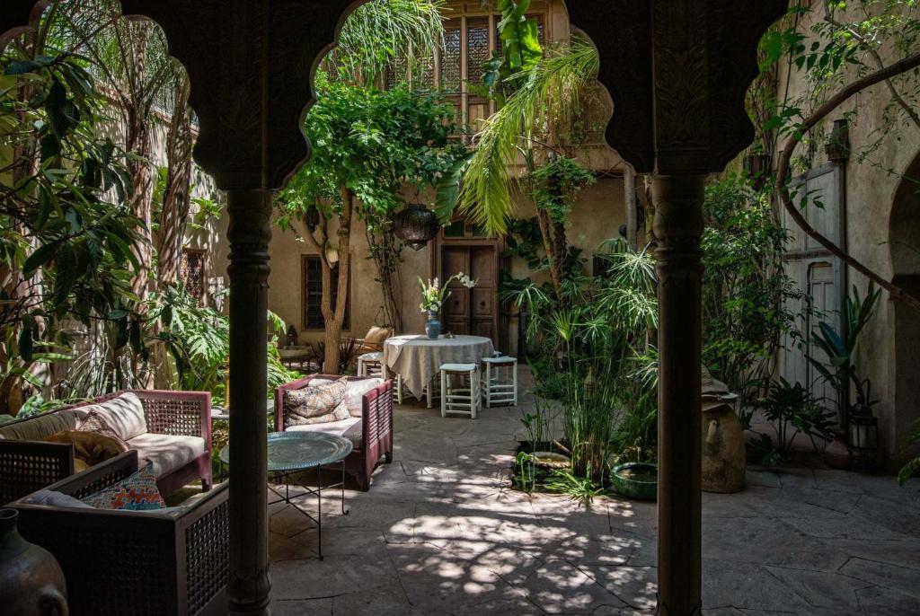 un patio avec une table, des chaises et des plantes dans l'établissement Riad Kbour & Chou, à Marrakech