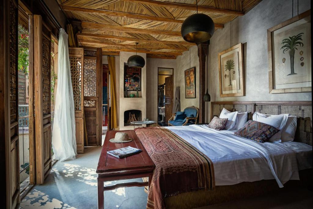 une chambre avec un grand lit avec un plafond en bois dans l'établissement Riad Kbour & Chou, à Marrakech