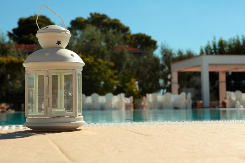 - une lanterne assise au sol à côté d'une piscine dans l'établissement Albergo 2 Pini, à Rodi Garganico