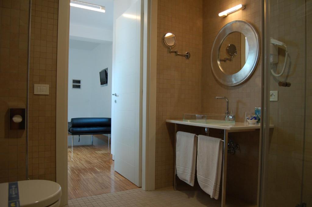 une salle de bain avec un lavabo et un miroir et des toilettes dans l'établissement Hotel Del Conte, à Fondi