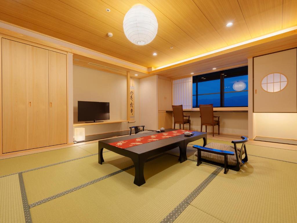 un salon avec une table et une télévision dans l'établissement Jyoseikan, à Kōchi