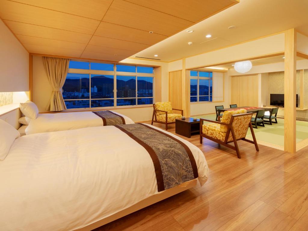 une chambre d'hôtel avec deux lits et une salle à manger dans l'établissement Jyoseikan, à Kōchi