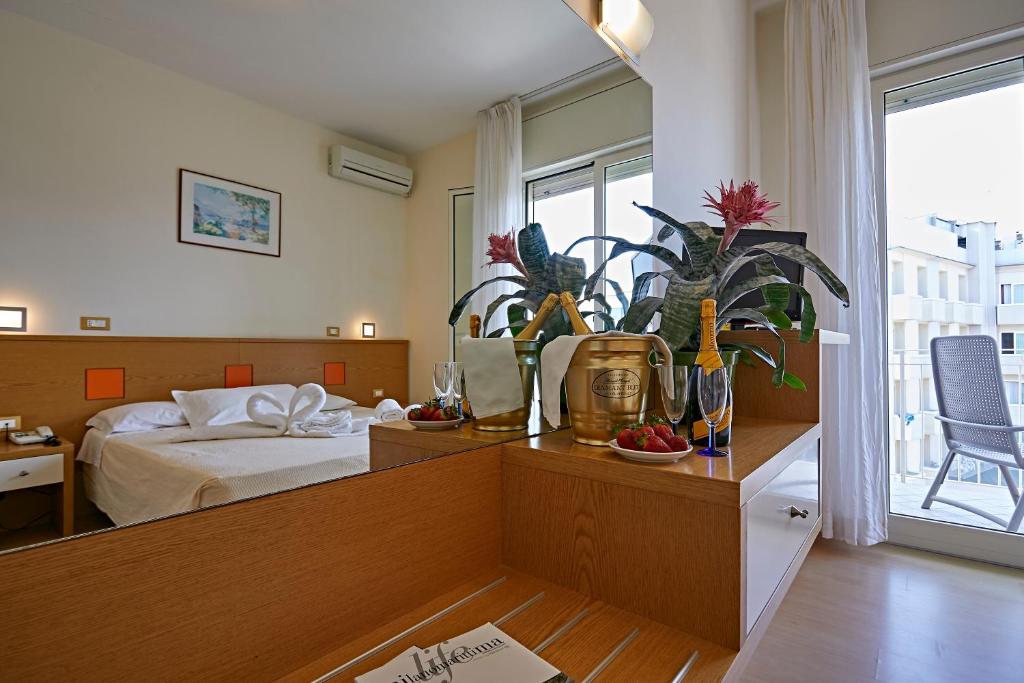 une chambre avec un lit et une table avec des plantes dans l'établissement Hotel Ridolfi, à Milano Marittima 136 autres photos