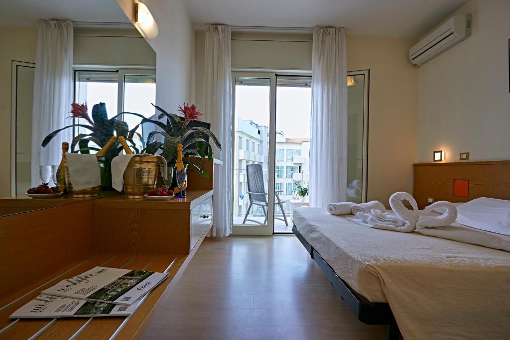 une chambre d'hôtel avec un lit et un balcon dans l'établissement Hotel Ridolfi, à Milano Marittima