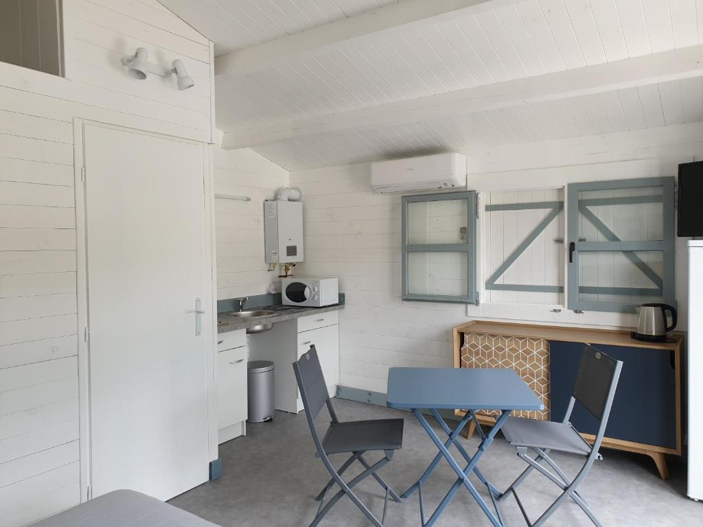une cuisine avec une table et des chaises dans une pièce dans l'établissement Gîte La Fontaine de Rocoule, à Rochefort-en-Valdaine
