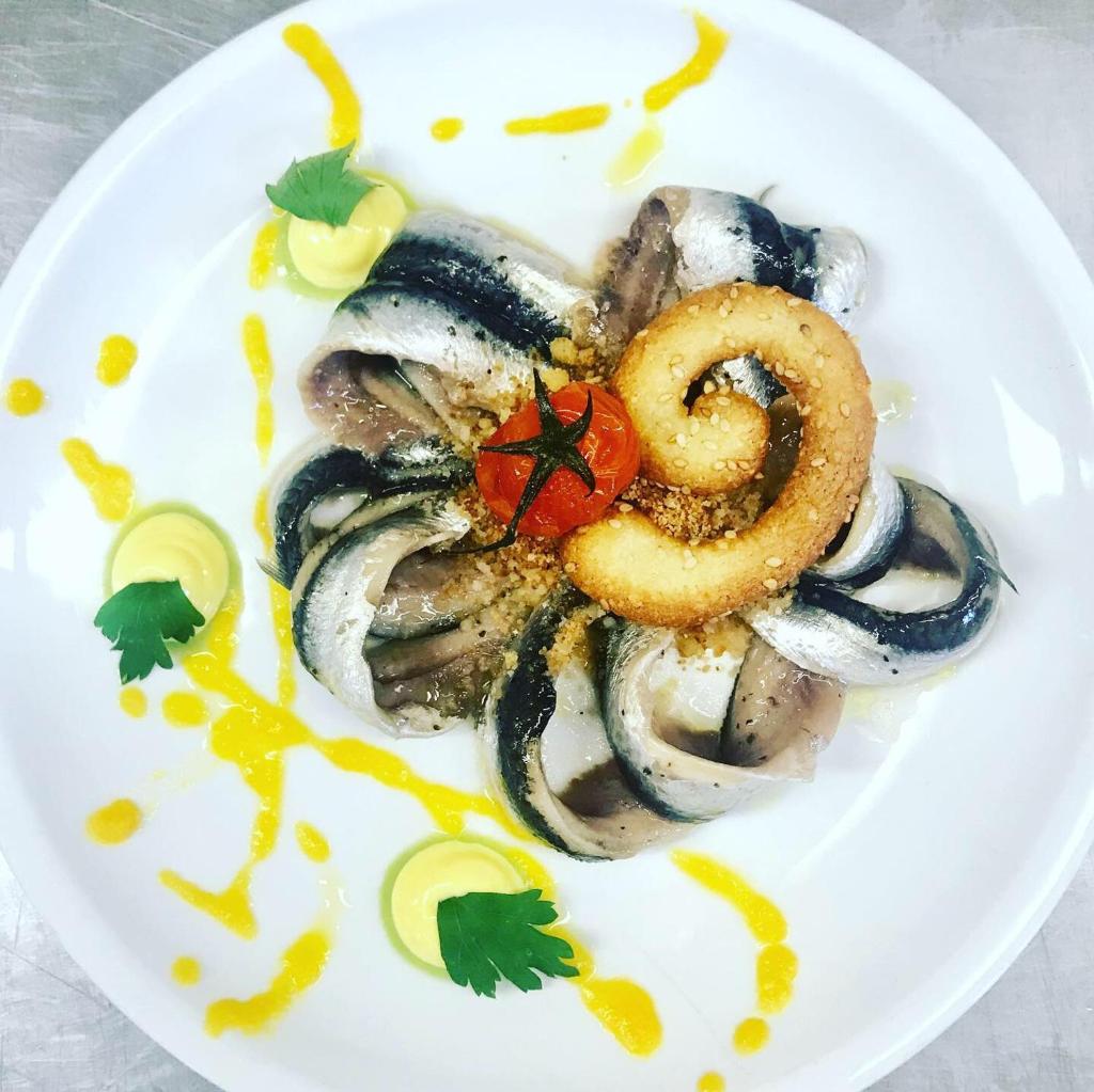 une assiette de nourriture avec du calmar et une tomate dans l'établissement Hotel Jole, à San Mauro a Mare