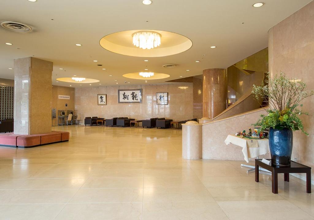 - un hall avec un coin d'attente doté d'une table et de chaises dans l'établissement Komoro Grand Castle Hotel, à Komoro